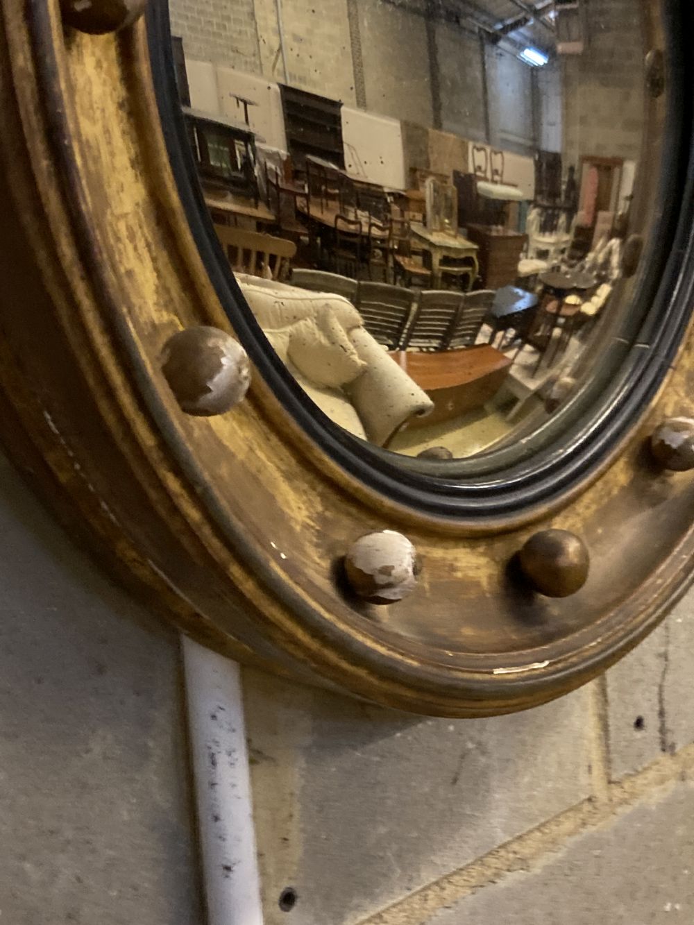 A Regency carved giltwood and gesso circular convex wall mirror with eagle pediment, height 69cm, width 50cm
